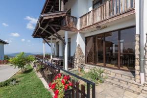 a balcony of a house with flowers on the side at Balkana Village in Kalaydzhii