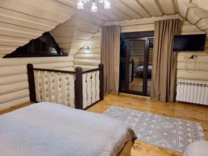 a bedroom with a bed and a tv in a room at Шепіт Карпат 2 in Synevyrsʼka Polyana
