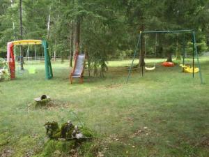 a park with two swings and a chair in the grass at Il était une fois in Champeau