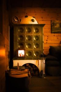 a fireplace in a living room with a stove at Almzeit Klippitz in Klippitztorl +18 photos
