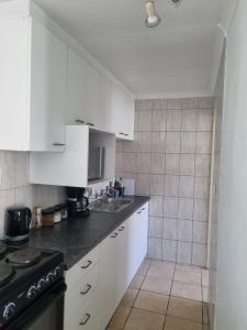a kitchen with white cabinets and a black stove at 4 Jooste Street in Windsor Park +20 photos