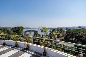 a balcony with trees and a view of the water at Staymaster Solintra A301 - Pool in Nerul