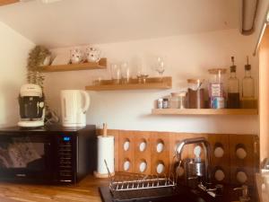 a kitchen with a microwave and a counter with a sink at Chalet La Romance in Prouilly