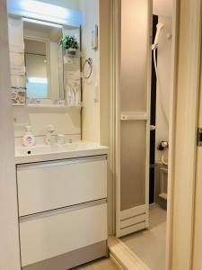 a white bathroom with a sink and a mirror at Le Amo吉塚 in Fukuoka +69 photos