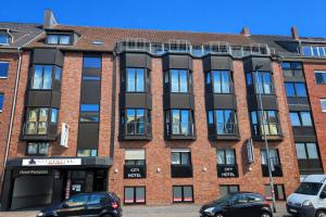 a brick building with cars parked in front of it at Cityhotel Amadeus - 3 Sterne Superior in Münster