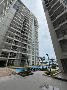 a large building with a swimming pool in front of it at MERE Suite Davao- One Lakeshore behind SM Lanang in Davao City