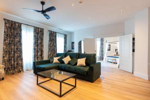 a living room with a green couch and a table at Hotel Duquesa Golf Club in San Luis de Sabinillas