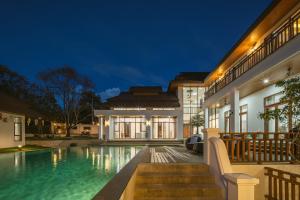 a villa with a swimming pool at night at Spoonamore Villa in Hang Dong