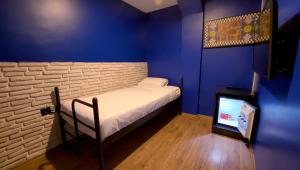 a small bed in a blue room with a tv at THINK HOTEL in Konya