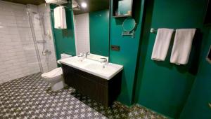 a bathroom with a sink and a toilet and green walls at THINK HOTEL in Konya +89 photos