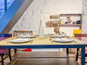 a wooden table with plates and glasses and a bottle at Appartement 5 personnes Centre d'Agde in Agde