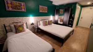 two beds in a room with green walls at THINK HOTEL in Konya