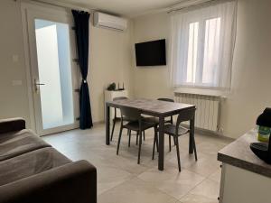 a living room with a table and chairs and a television at Appartamento DANTE in Pisogne +10 photos