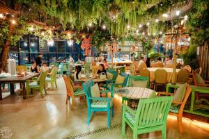 a restaurant with colorful chairs and tables and people eating at Capital CauGiay Hotel in Hanoi