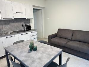 a living room with a table and a couch at Appartamento DANTE in Pisogne