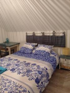 a bedroom with a blue and white bed with pillows at vive l'auvergne in Vensat