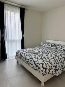 a bedroom with a bed with a black and white comforter at Appartamento DANTE in Pisogne