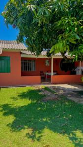 a house with a tree in front of it at Casa Refúgio Cataratas - Perto das Principais Atrações e do Aeroporto in Foz do Iguaçu