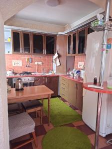 a kitchen with a table and a refrigerator at Садиба в Бабаєво in Perechin