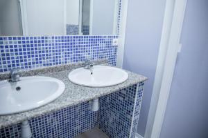 a blue tiled bathroom with two sinks and a mirror at AlbergueRojoPlata in Torremegía +11 photos