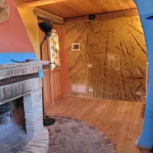 a living room with a fireplace and a wall with wood at Casa della Casa in San Severino Marche