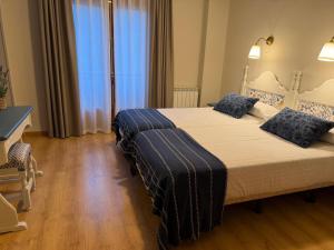 a bedroom with a large bed with blue pillows at Edelweiss Hotel in Torla-Ordesa