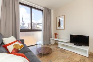 a living room with a couch and a tv at Picasso Suites in Barcelona