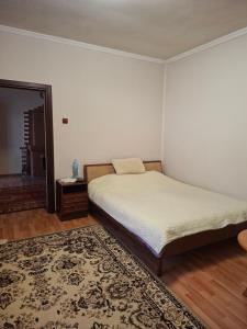 a bedroom with a bed and a rug at Садиба в Бабаєво in Perechin