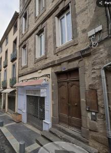 a brick building with a large door on a street at Appartement 5 personnes Centre d'Agde in Agde