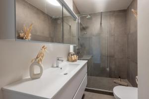 a bathroom with a white sink and a shower at Modern Cozy Studio - Prime location Knokke in Knokke-Heist