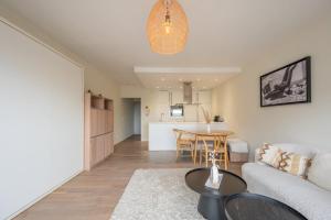 a living room with a couch and a table at Modern Cozy Studio - Prime location Knokke in Knokke-Heist +9 photos
