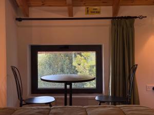 a table and chairs in a room with a window at Cyherbia Botanical Park & Labyrinth in Avgorou