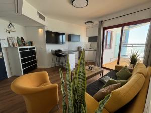 a living room with a couch and chairs and a kitchen at Lev Yam Suite in Netanya