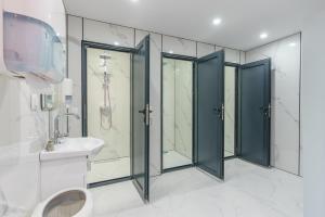 a bathroom with four shower stalls and a sink at Camping Bansko "Between the Mountains" in Bansko
