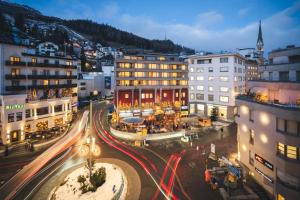 a city with buildings and traffic at night at Hauser Hotel St. Moritz in St. Moritz