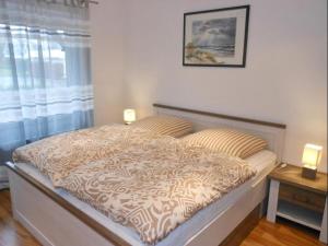 a bed in a bedroom with two lamps on it at Golfresidenz B 007 in Grömitz