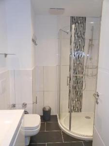 a white bathroom with a shower and a toilet at Golfresidenz B 007 in Grömitz +18 photos