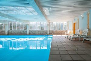 a large swimming pool with chairs at Golfresidenz B 007 in Grömitz