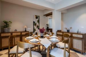 a dining room with a wooden table and chairs at Staymaster Solintra C301 - Pool in Nerul