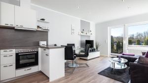 a kitchen and living room with a couch and a table at Golfresidenz B 003 in Grömitz