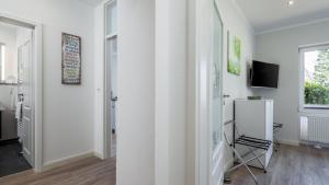 a white room with a chair and a television at Golfresidenz B 003 in Grömitz