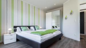 a bedroom with a large bed with green and white stripes at Golfresidenz B 003 in Grömitz +15 photos