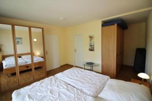 a bedroom with a large white bed and a mirror at Golfresidenz B 109 in Grömitz