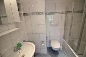 a bathroom with a toilet and a sink and a shower at Golfresidenz B 109 in Grömitz +10 photos