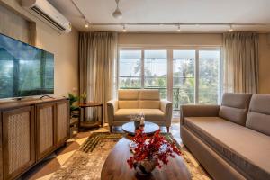 a living room with a couch and a tv at Staymaster Solintra C301 - Pool in Nerul