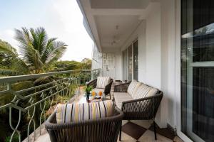 a patio with two chairs and a table on a balcony at Staymaster Solintra C301 - Pool in Nerul