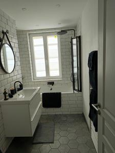a bathroom with a sink and a tub and a window at Porte de secours in Albertville +3 photos