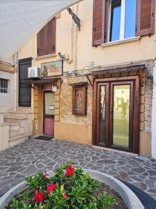 a building with a door and flowers in front of it at La Guglia - Maison à Porter in Vasto