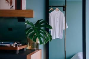 a white shirt hanging on a rack in a bedroom at Hotel She, Kyoto in Kyoto +66 photos