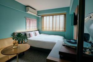 a hotel room with a bed and a table at Hotel She, Kyoto in Kyoto